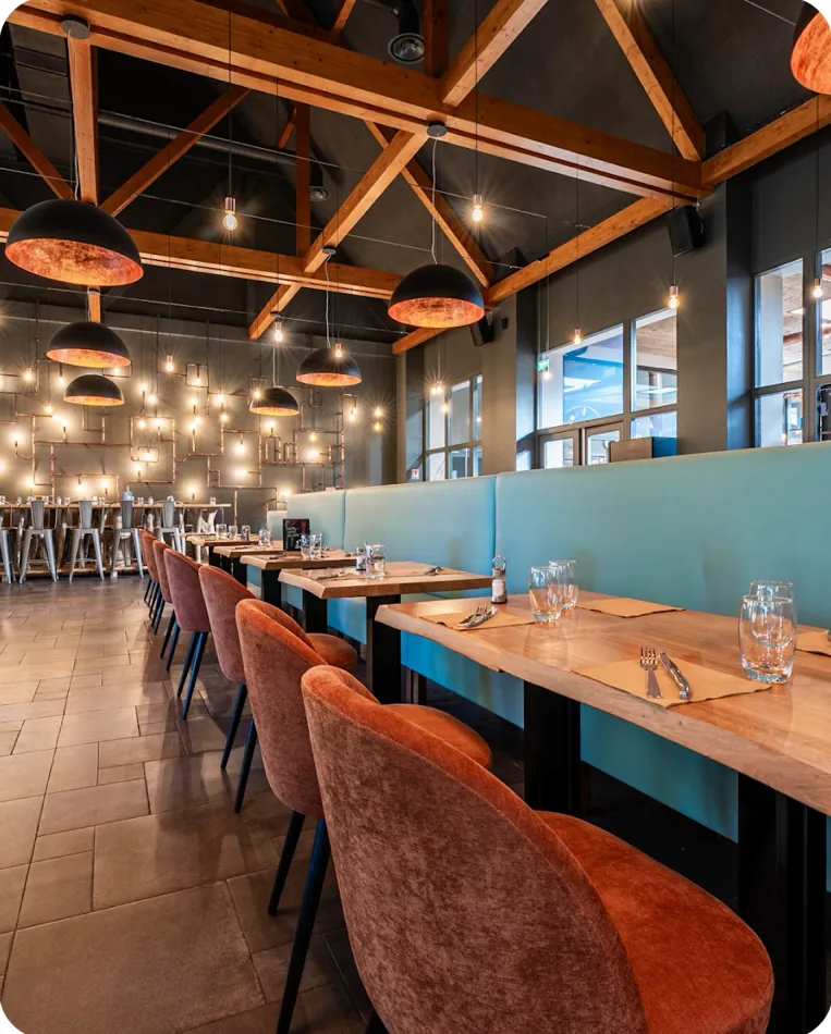 La grande salle : banquettes bleu canard et fauteuils en velours terracotta